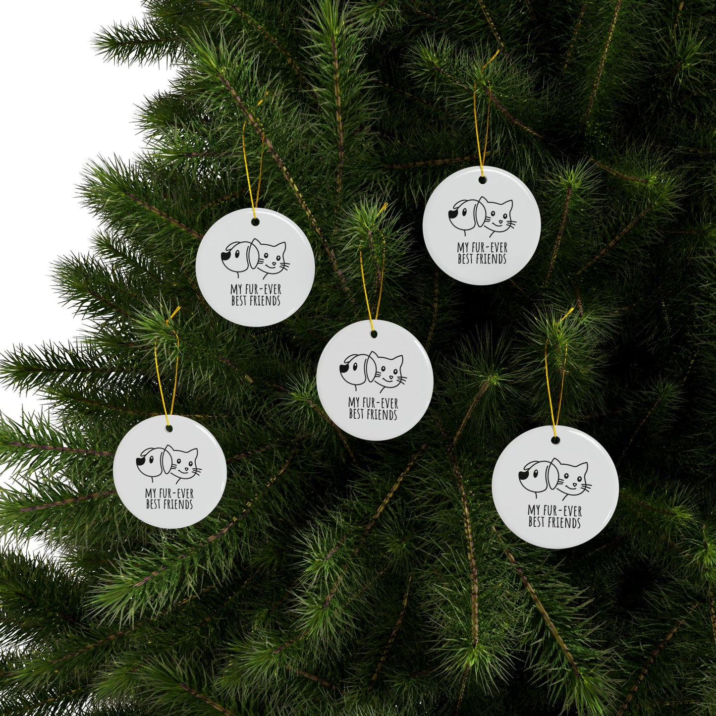 Five white ornaments with black cat illustrations hanging on a Christmas tree.