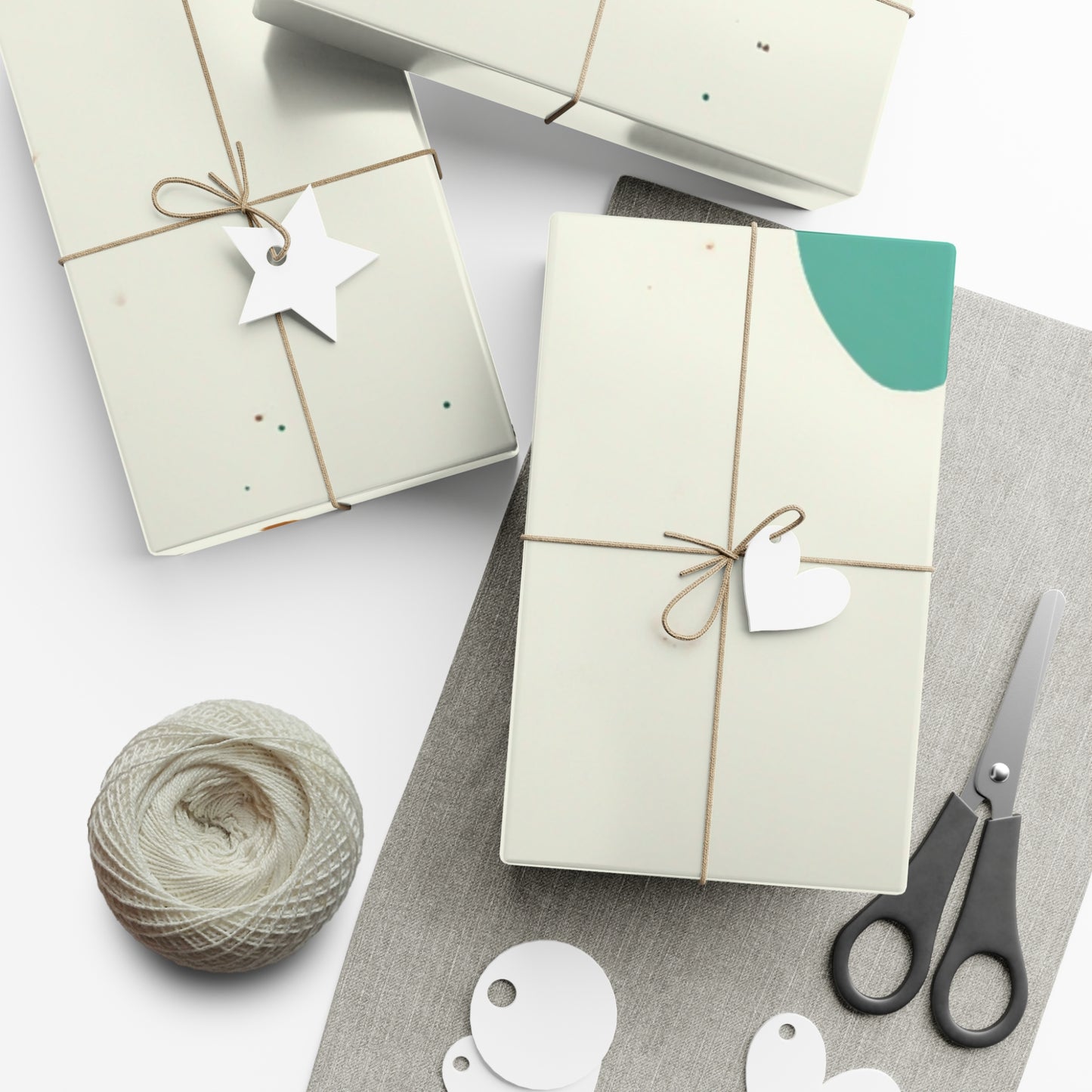Gift boxes with decorative tags, yarn, and scissors on a white surface