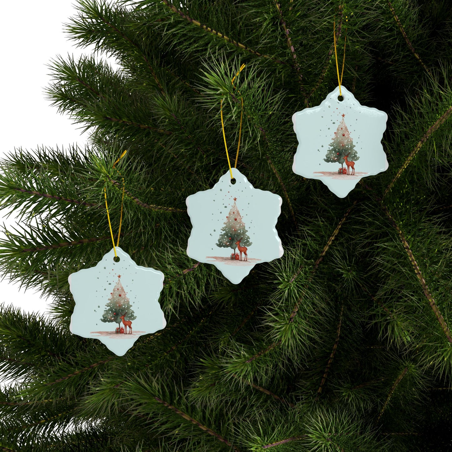 Three snowflake-shaped Christmas tree ornaments hanging on a green pine branch.