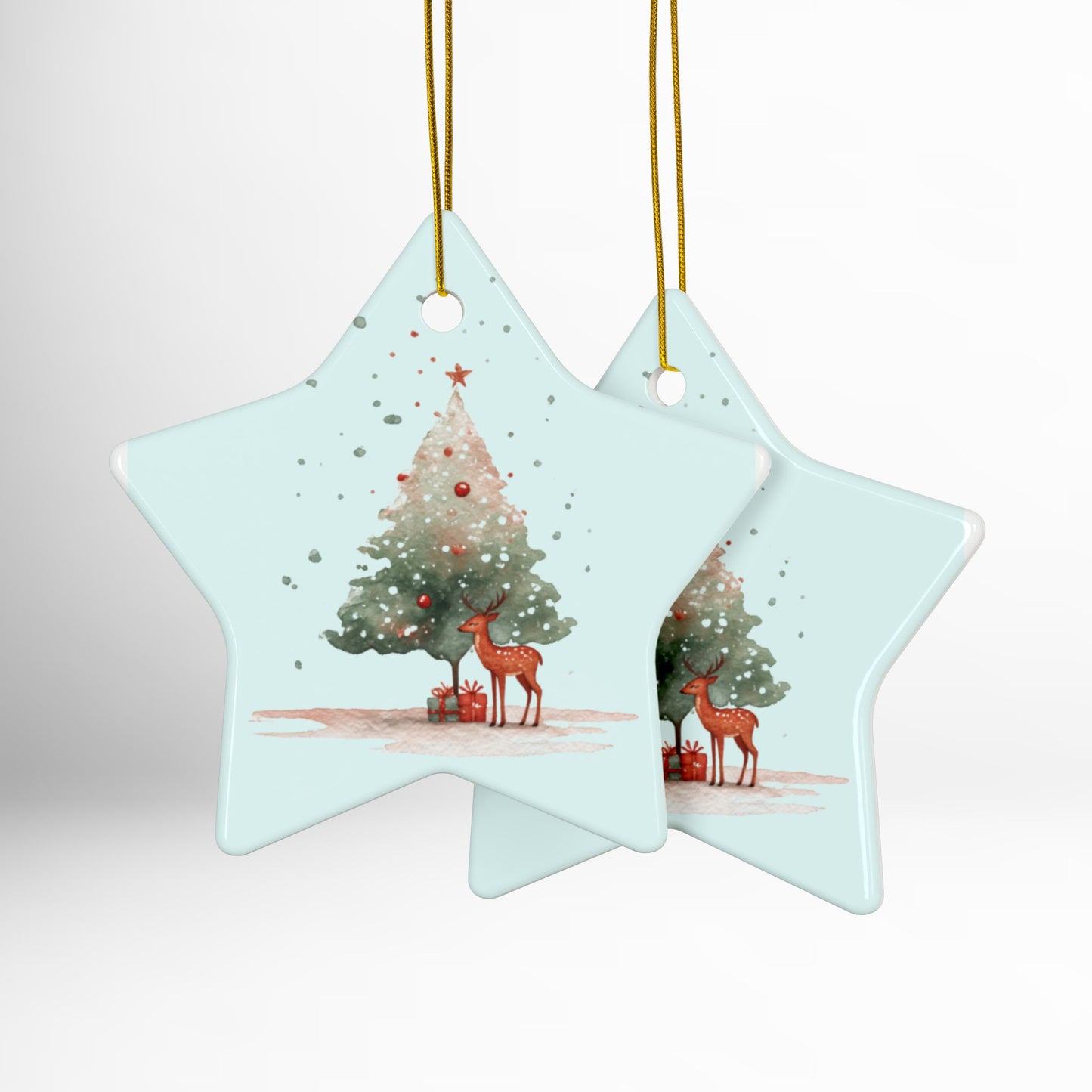 Two star-shaped Christmas ornaments with reindeer and trees on a light blue background.