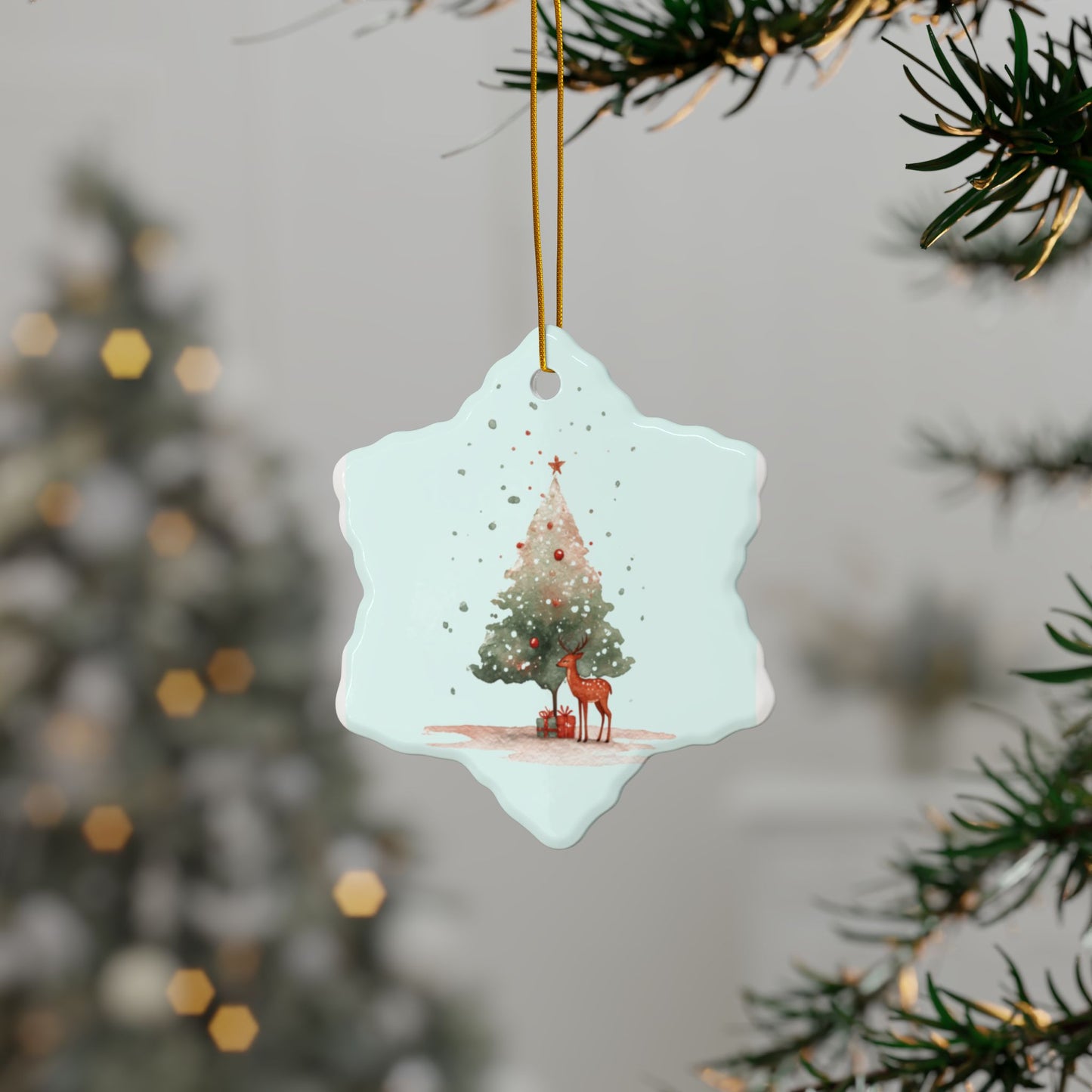Decorative snowflake ornament with a reindeer and Christmas tree design, hanging from a tree.