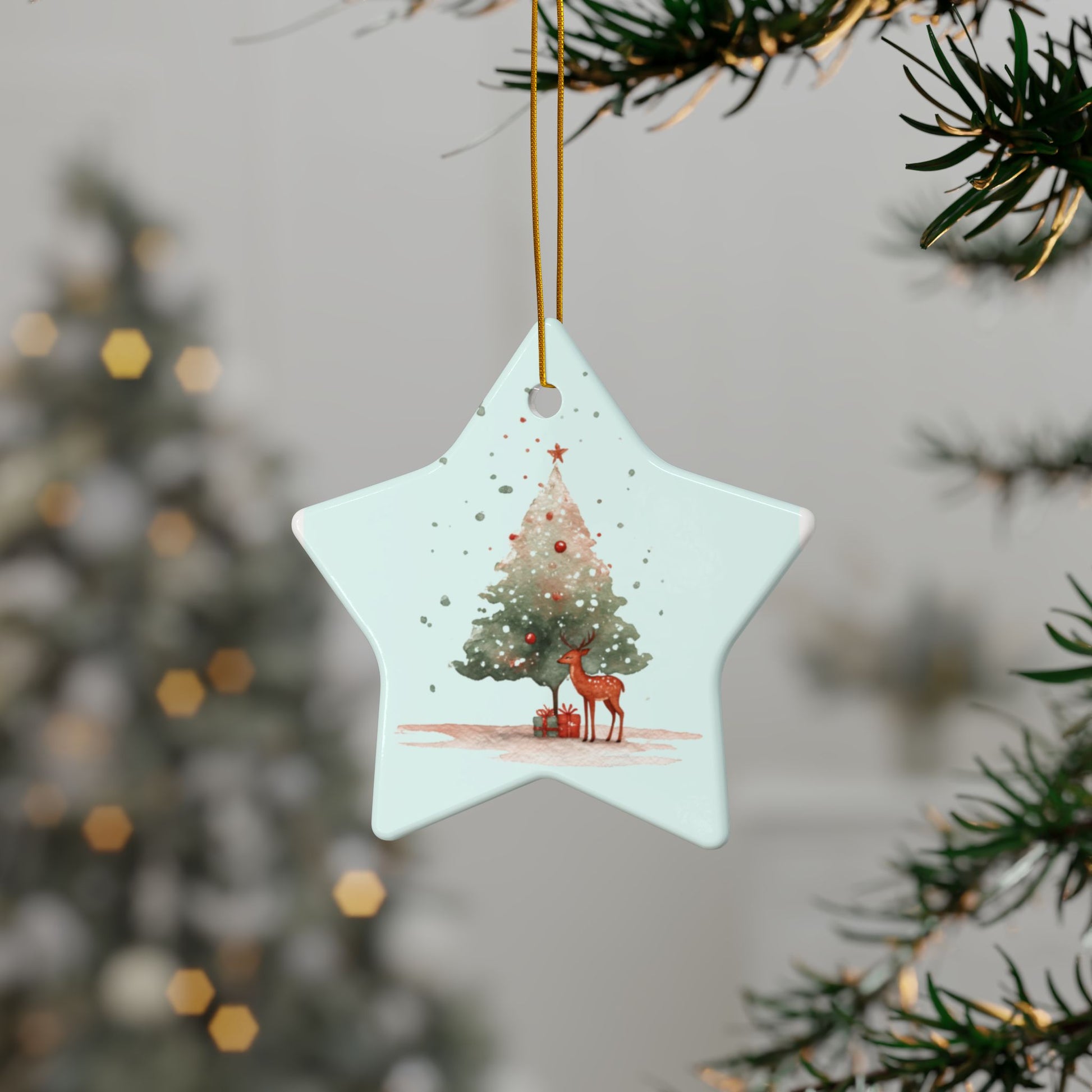 Star-shaped Christmas ornament with a tree and deer design, hanging from a tree.