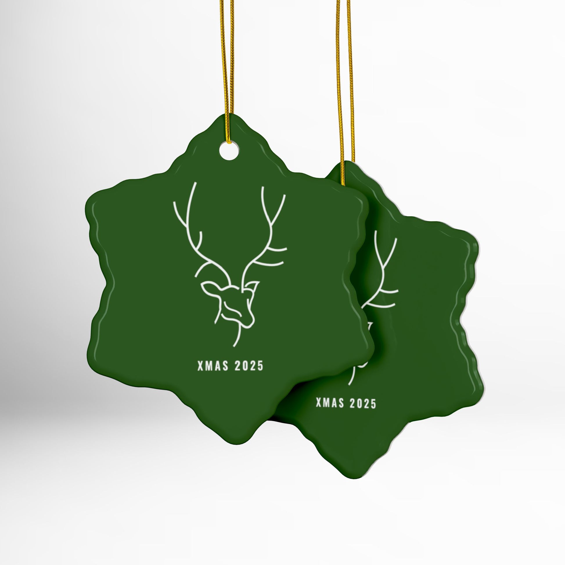Two green Christmas ornaments with deer design and 'XMAS 2025' text on a white background