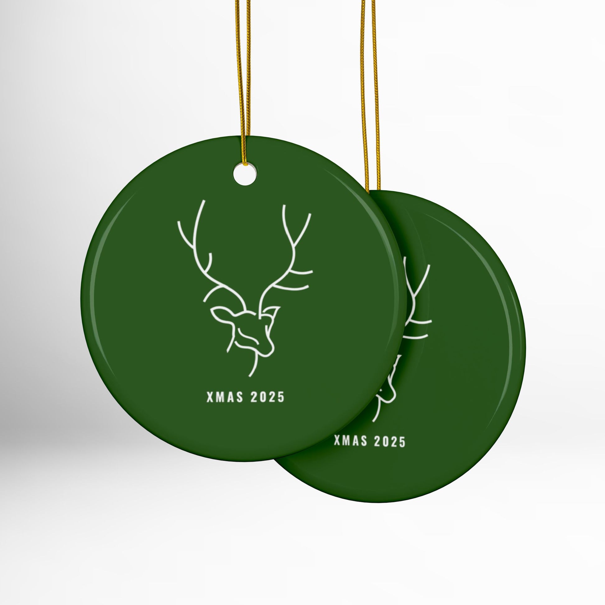 Two green Christmas ornaments with deer design and 'XMAS 2025' text on a white background