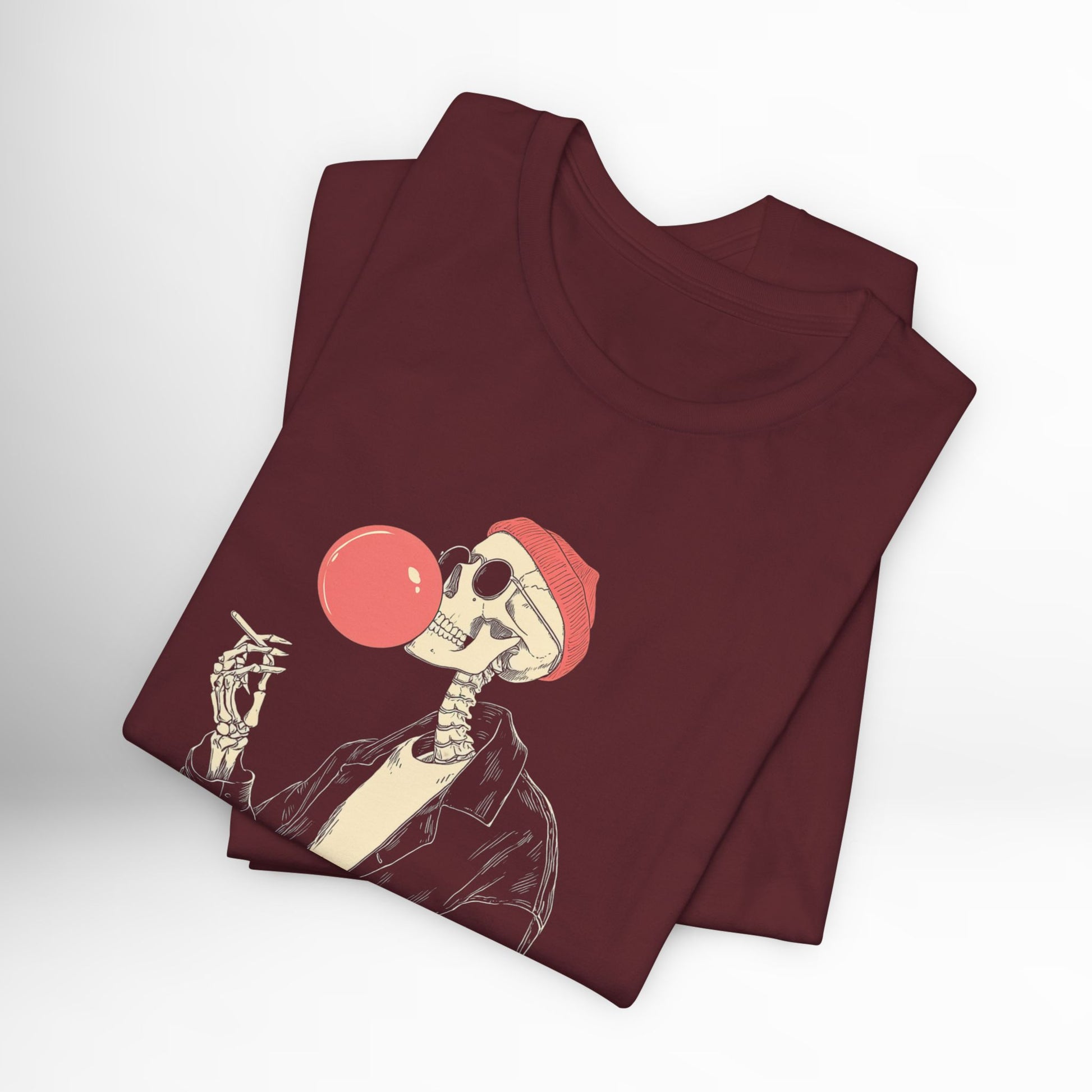 Maroon t-shirt with skeleton design blowing a bubble gum bubble on a white background