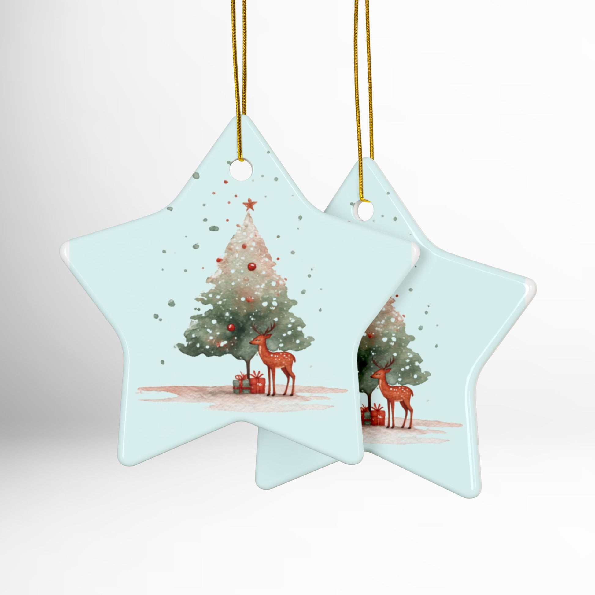 Two star-shaped Christmas ornaments with reindeer and trees on a light blue background.