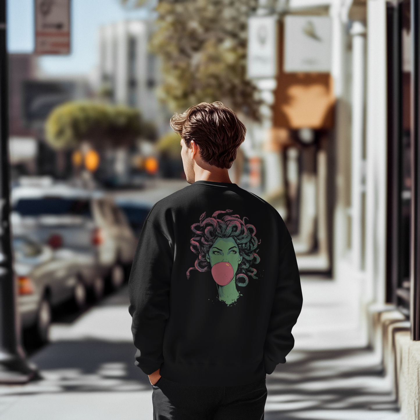 Person wearing a black sweatshirt with a colorful design on the back, standing on a city street.