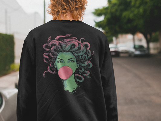 Person wearing a black sweatshirt with a colorful graphic of a woman blowing a bubble on the back, standing outdoors.